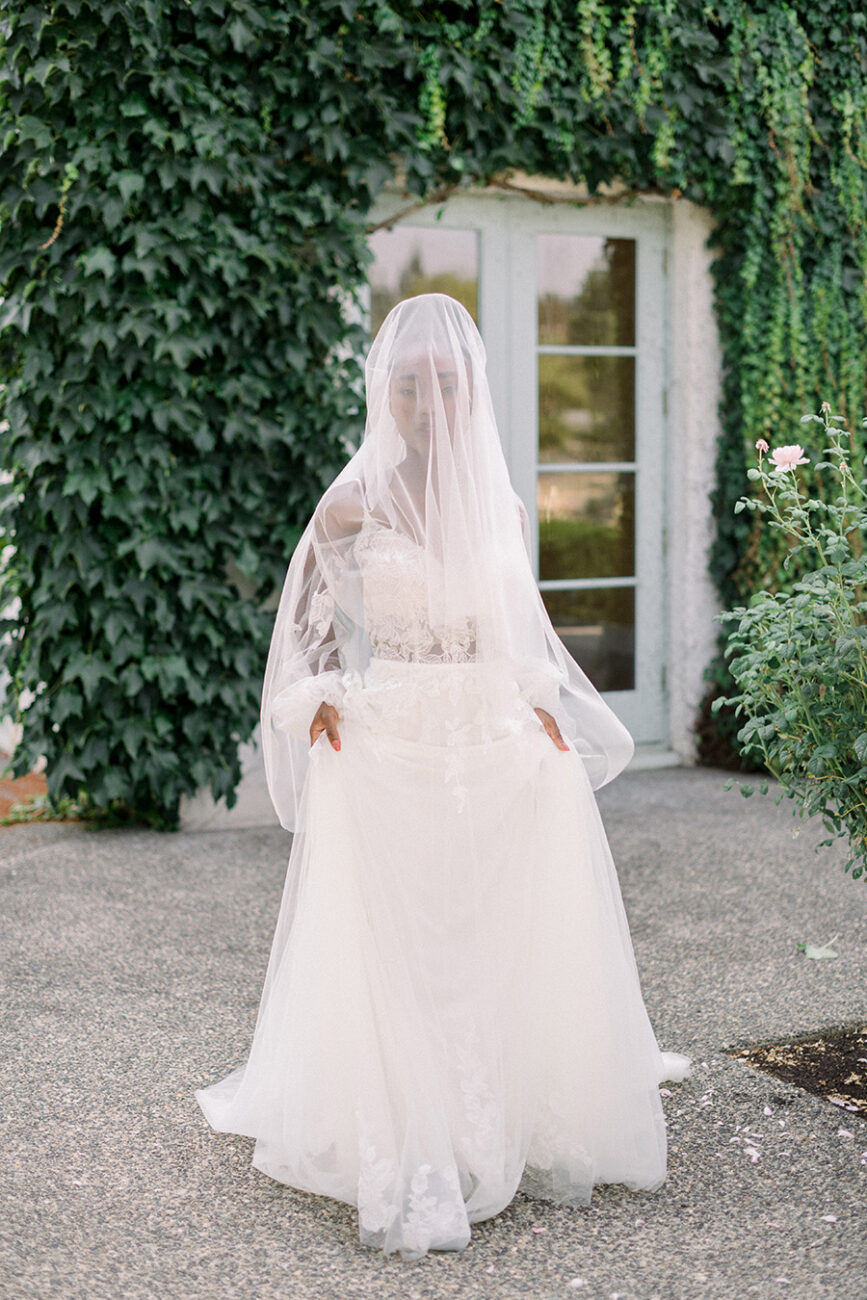 Beautiful black women in a bridal veil over face and gorgeous wedding gown