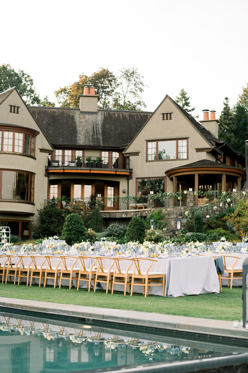 Home wedding rehearsal dinner in the backyard with a pool and large luxury home